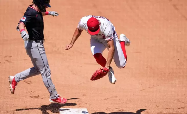 Los Angeles Angels second baseman Oswald Peraza, right, jumps as he misses a throw from first baseman Vaughn Grissom in an attempt to force Cleveland Guardians' Travis Bazzana out at first during the third inning of a baseball game Wednesday, Aug. 26, 2026, in Anaheim, Calif. (AP Photo/Mark J. Terrill)