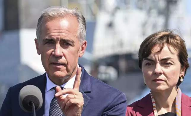 Canadian Prime Minister Mark Carney speaks as he announces a $11.3 billion contract for icebreakers at the Davie shipyard in Levis, Quebec, Monday, Aug. 24, 2026. Quebec Premier Christine Frechette, right, looks on. (Jacques Boissinot/The Canadian Press via AP)