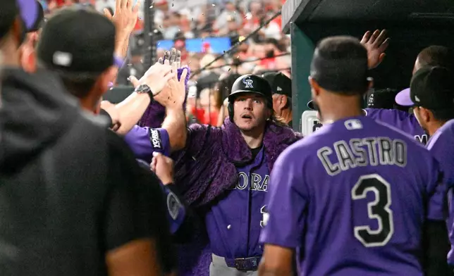Colorado Rockies' Jake McCarthy, center, is congratulated after scoring a home run during the top of the sixth inning of a baseball game against the St. Louis Cardinals, Saturday, Aug. 8, 2026, in St. Louis. (AP Photo/Lexie Knight)