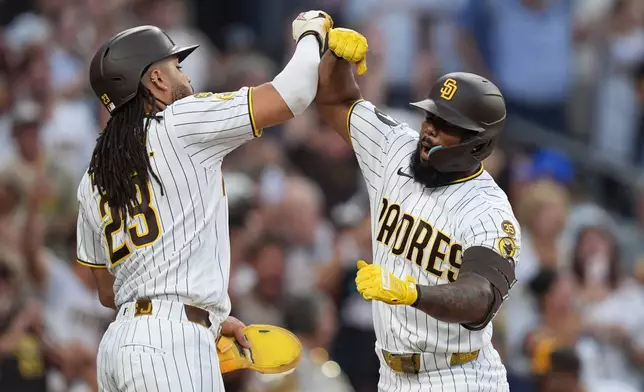 San Diego Padres' Luis Rengifo, right, celebrates with teammate Fernando Tatis Jr. after hitting a grand slam home run during the second inning of a baseball game against the Milwaukee Brewers Tuesday, Aug. 11, 2026, in San Diego. (AP Photo/Gregory Bull)