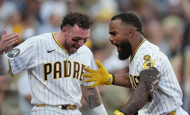 San Diego Padres' Luis Rengifo, right, celebrates with teammate Jackson Merrill after hitting a grand slam home run during the second inning of a baseball game against the Milwaukee Brewers Tuesday, Aug. 11, 2026, in San Diego. (AP Photo/Gregory Bull)