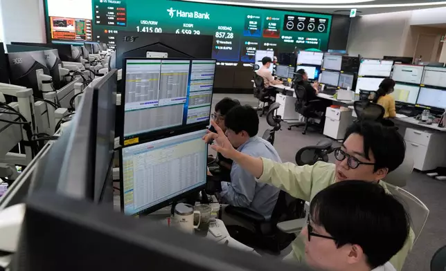 Currency traders work at the foreign exchange dealing room of the Hana Bank headquarters in Seoul, South Korea, Wednesday, Aug. 12, 2026. (AP Photo/Ahn Young-joon)
