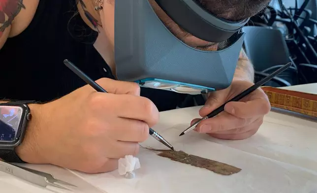 Papyrus Conservation Summer Seminar student Mimi Zycherman examines a papyrus fragment at the University of Michigan Thursday, Aug. 6, 2026, in Ann Arbor, Mich. (AP Photo/Mike Householder)