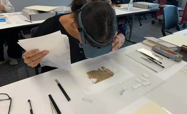 Papyrus Conservation Summer Seminar student Alessandra Quadrelli examines a papyrus fragment at the University of Michigan Thursday, Aug. 6, 2026, in Ann Arbor, Mich. (AP Photo/Mike Householder)