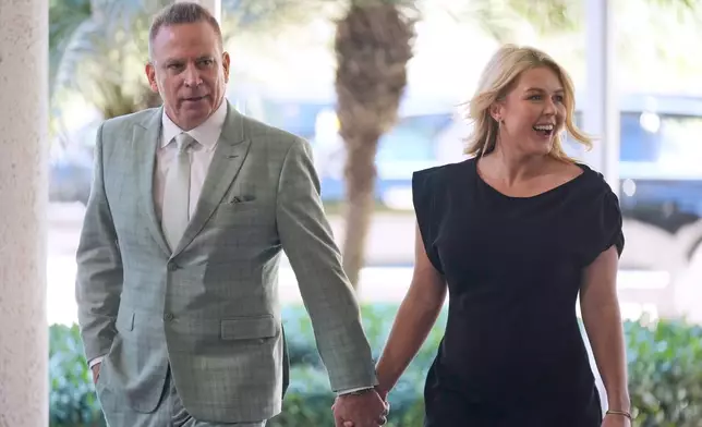 FILE - White House press secretary Karoline Leavitt and her husband Nicholas Riccio arrive at The Mar-a-Lago Club, Feb. 1, 2026, in Palm Beach, Fla., to attend the wedding of White House deputy chief of staff Dan Scavino and Erin Elmore, the director of Art in Embassies at the U.S. Department of State. (AP Photo/Mark Schiefelbein, File)
