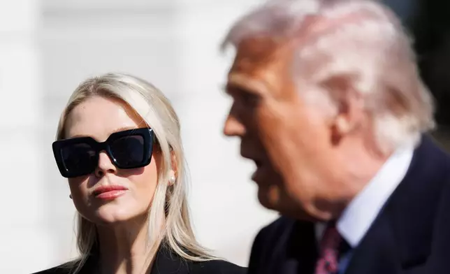FILE - Press Secretary Karoline Leavitt glances at President Donald Trump before departing on Marine One from the South Lawn of the White House, Feb. 27, 2026, in Washington. (AP Photo/Tom Brenner, File)