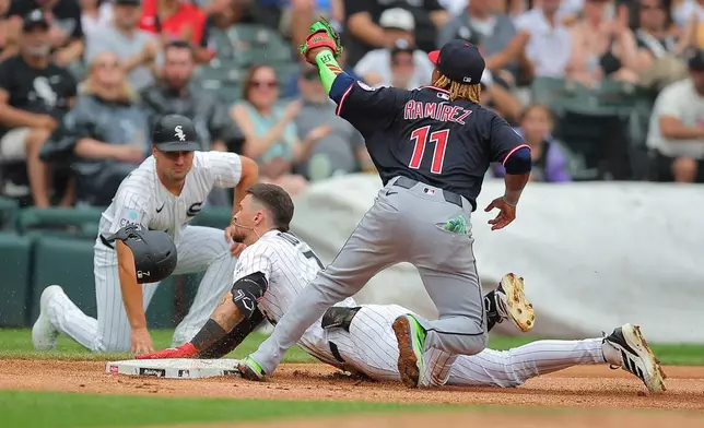 Cleveland Guardians' José Ramírez (11) tags out Chicago White Sox's Brenton Doyle, center, who was trying to extend a double into a triple during the third inning of a baseball game Sunday, Aug. 9, 2026, in Chicago. (AP Photo/Melissa Tamez)