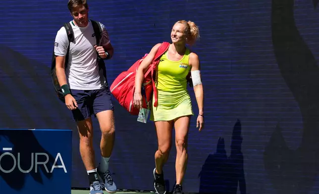 Henry Patten, of Britain, left, and Katerina Siniakova, of the Czech Republic, arrive on the court ahead of a mixed doubles match at the U.S. Open tennis championships, Tuesday, Aug. 25, 2026, in New York. (AP Photo/Yuki Iwamura)