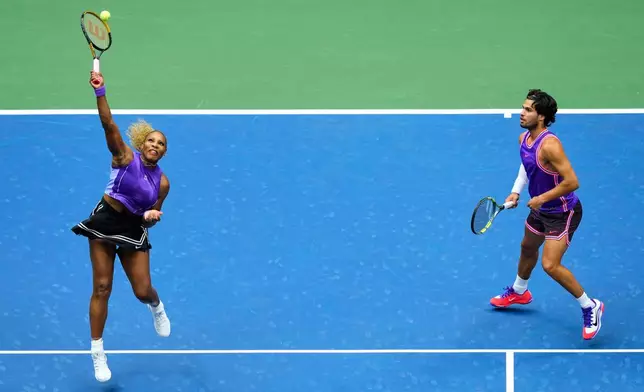 Serena Williams, of the United States, and Carlos Alcaraz, of Spain, return the ball during a mixed doubles match at the U.S. Open tennis championships, Tuesday, Aug. 25, 2026, in New York. (AP Photo/Yuki Iwamura)