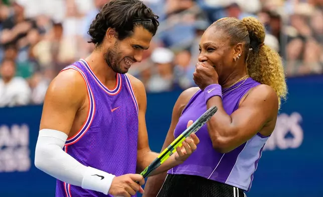 Carlos Alcaraz, of Spain, left, and Serena Williams, of the United States, talk on the court during a mixed doubles match at the U.S. Open tennis championships, Tuesday, Aug. 25, 2026, in New York. (AP Photo/Yuki Iwamura)
