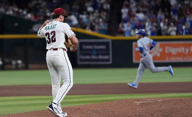 Arizona Diamondbacks starting pitcher Brandon Pfaadt (32) pauses on the pitcher's mound after giving up a three-run home run to Chicago Cubs' Ian Happ, right, during the fourth inning of a baseball game, Tuesday, Aug. 25, 2026, in Phoenix. (AP Photo/Ross D. Franklin)