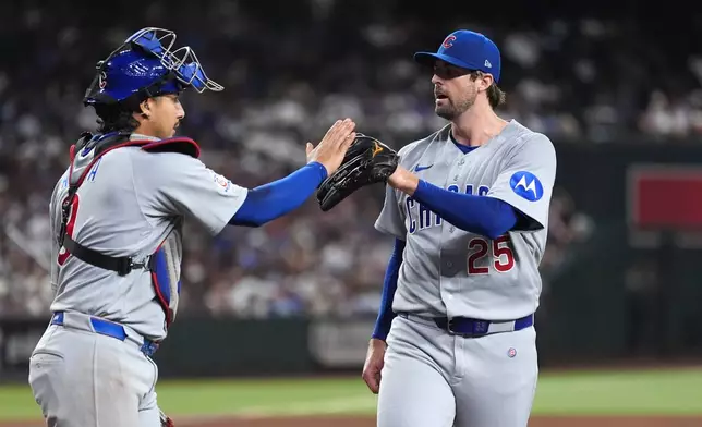 Chicago Cubs pitcher Clay Holmes (25) celebrates retiring the Arizona Diamondbacks with Cubs catcher Miguel Amaya, left, during the sixth inning of a baseball game, Tuesday, Aug. 25, 2026, in Phoenix. (AP Photo/Ross D. Franklin)