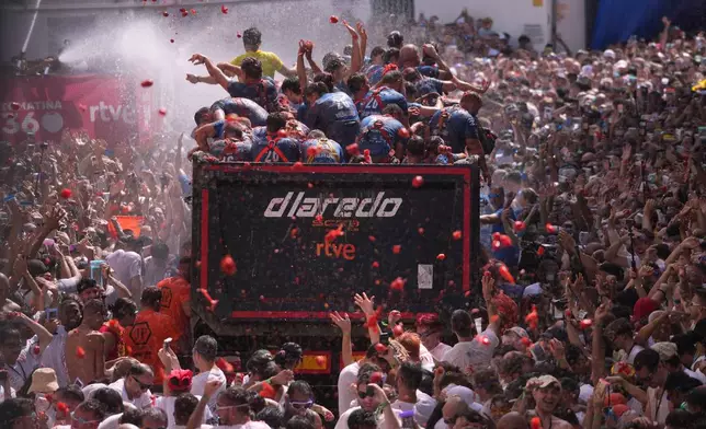 Revelers throw tomatoes at each other during the annual "Tomatina" tomato fight fiesta, in the village of Bunol near Valencia, Spain, Wednesday, Aug. 26, 2026. (AP Photo/Alberto Saiz)