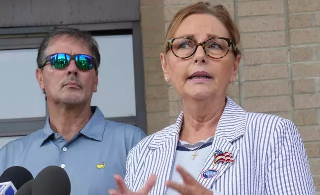 Larry Nordone looks on as his wife, U.S. Sen. Darline Graham, R-S.C., speaks to reporters after she voted in a special Republican primary to replace her brother, U.S. Sen. Lindsey Graham, R-S.C., on November ballots on Tuesday, Aug. 11, 2026, in Florence, S.C. (AP Photo/Meg Kinnard)