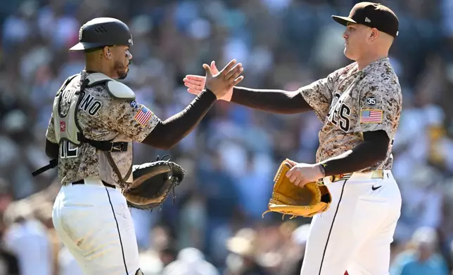 San Diego Padres catcher Luis Campusano, left, and pitcher Adrian Morejon, right, celebrate after their team defeated the San Francisco Giants in a baseball game Sunday, Aug. 2, 2026, in San Diego. (AP Photo/Denis Poroy)