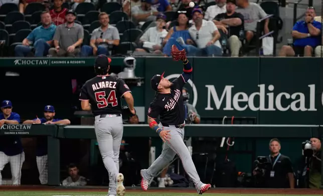 Washington Nationals first baseman Andrés Chaparro, right, reaches up to catch a pop out by Texas Rangers' Jake Burger as pitcher Andrew Alvarez (54) looks on in the fifth inning of a baseball game Thursday, Aug. 20, 2026, in Arlington, Texas. (AP Photo/Tony Gutierrez)