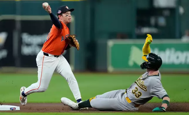 Houston Astros shortstop Nick Allen, left, turns a double play after forcing out Athletics' Henry Bolte (33) during the first inning of a baseball game Friday, Aug. 21, 2026, in Houston. (AP Photo/Kevin M. Cox)