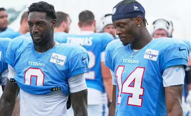 Tennessee Titans wide receivers Calvin Ridley (0) and Carnell Tate (14) stand stand together after practice during the NFL football team's training camp Tuesday, Aug. 4, 2026, in Nashville, Tenn. (AP Photo/George Walker IV)