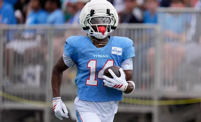 Tennessee Titans wide receiver Carnell Tate (14) runs with the ball during the NFL football team's training camp Tuesday, Aug. 4, 2026, in Nashville, Tenn. (AP Photo/George Walker IV)