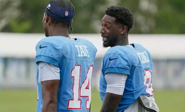Tennessee Titans wide receivers Calvin Ridley, right, Carnell Tate (14) talks with each other after practice during the NFL football team's training camp Tuesday, Aug. 4, 2026, in Nashville, Tenn. (AP Photo/George Walker IV)