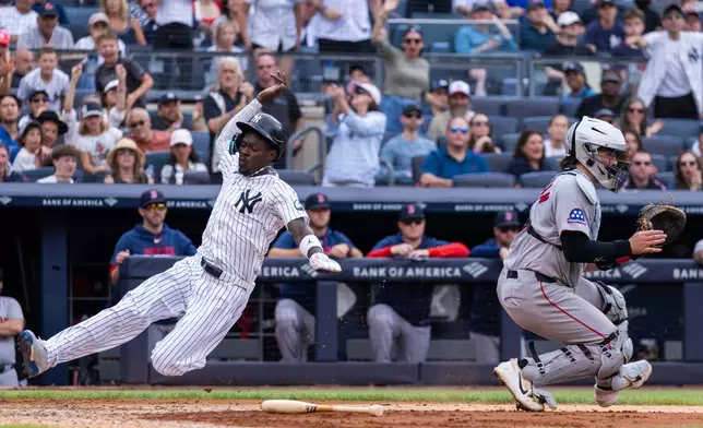 New York Yankees' Jazz Chisholm Jr. scores past Boston Red Sox catcher Adley Rutschman, right, after Yankees' Paul Goldschmidt hit a two-RBI single in the fifth inning during a baseball game, Sunday, Aug. 30, 2026, in New York. (AP Photo/Corey Sipkin)
