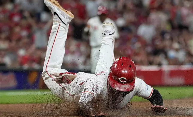 Cincinnati Reds' Sal Stewart dives across home plate to score the go-ahead run on a wild pitch by Athletics pitcher Hogan Harris during the eight inning of a baseball game in Cincinnati, Tuesday, Aug. 4, 2026. (AP Photo/Carolyn Kaster)