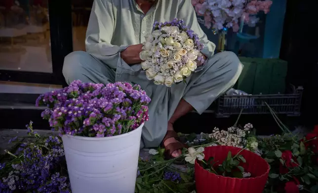 A flower seller arranges bouquets ahead of celebrations marking the fifth anniversary of the U.S. withdrawal and the start of Taliban rule in Kabul, Afghanistan, Friday, Aug. 14, 2026. (AP Photo/Nava Jamshidi)