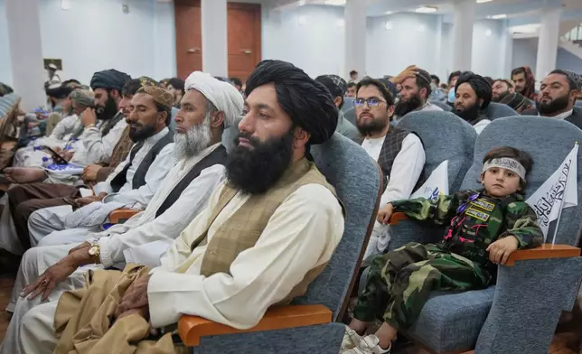 A boy sits among Taliban delegates from across the country during a meeting opening celebrations marking the fifth anniversary of the U.S. withdrawal and the Taliban's return to power, at Loya Jirga Hall in Kabul, Afghanistan, Saturday, Aug. 15, 2026. (AP Photo/Siddiqullah Alizai)