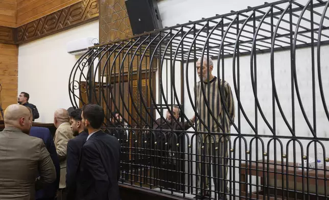 Syria's former grand mufti under ousted President Bashar Assad, Ahmad Badreddine Hassoun, stands as he listens a court sentence of life in prison at the Palace of Justice in Damascus, Syria, Monday, Aug. 24, 2026. (AP Photo/Ghaith Alsayed)