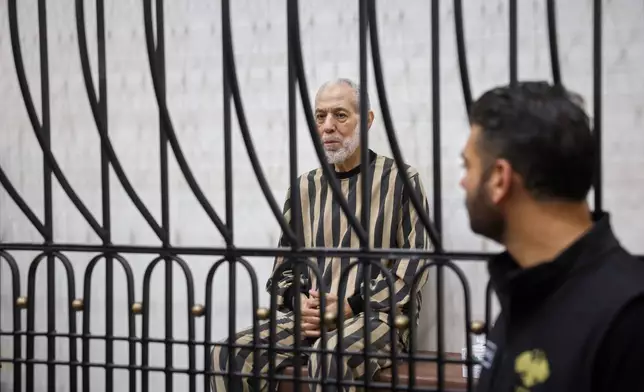 Syria's former grand mufti under ousted President Bashar Assad, Ahmad Badreddine Hassoun, sits in the defendants' cage before a court sentences him to life in prison at the Palace of Justice in Damascus, Syria, Monday, Aug. 24, 2026. (AP Photo/Ghaith Alsayed)
