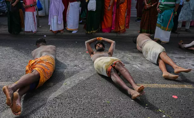 Worshippers perform an act of sacrifice as they take part in the Hindu Chariot Festival, a celebration to worship the Hindu god Amman, in London, Sunday, Aug. 9, 2026. (AP Photo/Kirsty Wigglesworth)