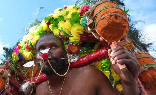 A worshipper takes part in the Hindu Chariot Festival, a celebration to worship the Hindu god Amman, in London, Sunday, Aug. 9, 2026. (AP Photo/Kirsty Wigglesworth)