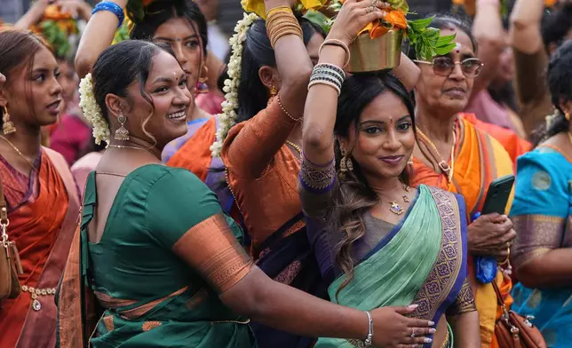 Women take part in the Hindu Chariot Festival, a celebration to worship the Hindu god Amman, in London, Sunday, Aug. 9, 2026. (AP Photo/Kirsty Wigglesworth)