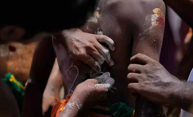 Hindu devotees with hooks pierced through the skin on their backs take part in the Aadi festival, a holy month for Tamils observed with prayers and offerings to Hindu goddesses, in Chennai, India, Sunday, Aug. 9, 2026. (AP Photo/Mahesh Kumar A.)
