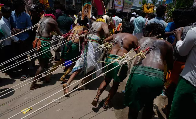 Hindu devotees with their back pierced with hooks pull the chariot of goddess during 'Aadi' festival, a holy month for Tamils observed with prayers and offerings to Hindu goddesses, in Chennai, India, Sunday, Aug. 9, 2026. (AP Photo/Mahesh Kumar A.)