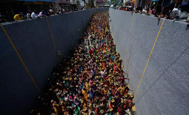Hindu devotees carry milk pots during a procession to perform rituals for the 'Aadi' festival, a holy month for Tamils observed with prayers and offerings to Hindu goddesses, in Chennai, India, Sunday, Aug. 9, 2026. (AP Photo/Mahesh Kumar A.)