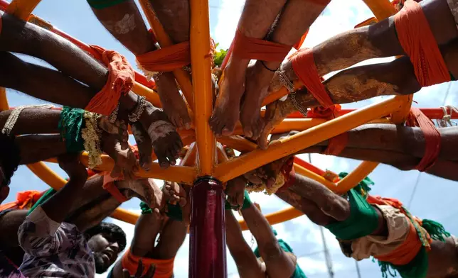 Hindu devotees with their back pierced with hooks spin during 'Aadi' festival, a holy month for Tamils observed with prayers and offerings to Hindu goddesses, in Chennai, India, Sunday, Aug. 9, 2026. (AP Photo/Mahesh Kumar A.)