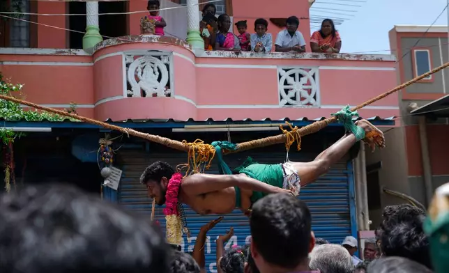 A Hindu devotee with his back pierced with hooks perform rituals during 'Aadi' festival, a holy month for Tamils observed with prayers and offerings to Hindu goddesses, in Chennai, India, Sunday, Aug. 9, 2026. (AP Photo/Mahesh Kumar A.)
