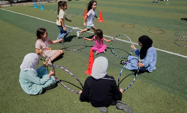 Displaced children play during an event organised by Save the Children, at a public school turned into a shelter for people whose villages in southern Lebanon were destroyed or occupied by Israeli forces, in Tyre, southern Lebanon, Thursday, Aug. 27, 2026. (AP Photo/Hussein Malla)