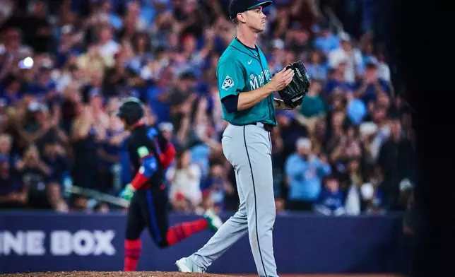 Seattle Mariners pitcher Emerson Hancock, right, reacts as Toronto Blue Jays' George Springer, back left, rounds the bases after hitting a solo home run during the fifth inning of a baseball game in Toronto, Friday, Aug. 28, 2026. (Sammy Kogan/The Canadian Press via AP)