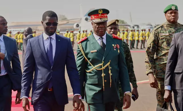 FILE - Guinea-Bissau Transitional President General Horta Inta-A-Na Man, centre, and President of Senegal Bassirou Diomaye Faye walk during an official ECOWAS mission to help resolve Guinea-Bissau's political crisis in Bissau, Guinea-Bissau, on Jan. 10, 2026. (AP Photo/Abubacar Queta, File)