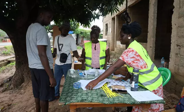 Voters prepare to cast their ballots during a referendum on granting new presidential powers, in Bissau, Guinea Bissau, Sunday, Aug. 30, 2026. (AP Photo/Darcicio Barbosa)