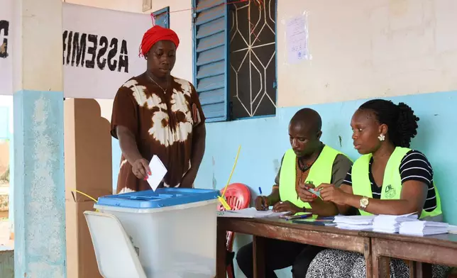 A voter casts her ballot during a referendum on granting new presidential powers, in Bissau, Guinea Bissau, Sunday, Aug. 30, 2026. (AP Photo/Darcicio Barbosa)