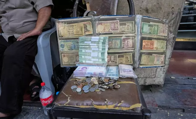 Current and pre-revolution Iranian banknotes are displayed by a street money exchanger at Ferdowsi square, a hub for foreign currency trading in downtown Tehran, Iran, Monday, Aug. 24, 2026. (AP Photo/Vahid Salemi)