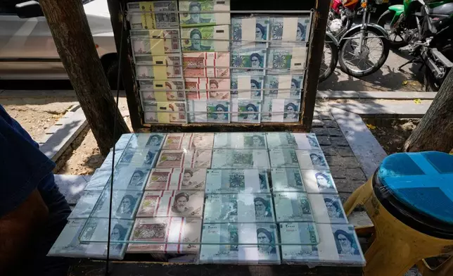 Iranian banknotes are displayed by a street money exchanger at Ferdowsi square, Tehran's go-to venue for foreign currency exchange, in downtown Tehran, Iran, Monday, Aug. 24, 2026. AP Photo/Vahid Salemi)