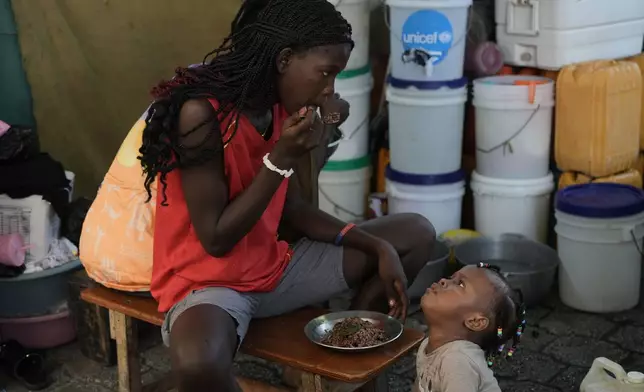 Children eat at a shelter for families displaced by gang violence in Port-au-Prince, Haiti, Wednesday, Aug. 19, 2026. (AP Photo/Odelyn Joseph)
