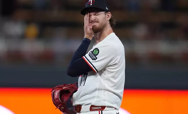 Minnesota Twins starter Bailey Ober wipes his face as manager Derek Shelton walks to the mound to make a pitching change during the fifth inning of a baseball game against the Atlanta Braves, Monday, Aug. 17, 2026, in Minneapolis. (AP Photo/Abbie Parr)