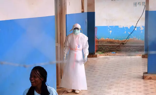 A health worker, wearing protective gear, stands outside the Ebola Treatment Center at the Bunia General Hospital in Ituri, Congo, Wednesday, July 22, 2026. (AP Photo/Dirole Lotsima Dieudonne)