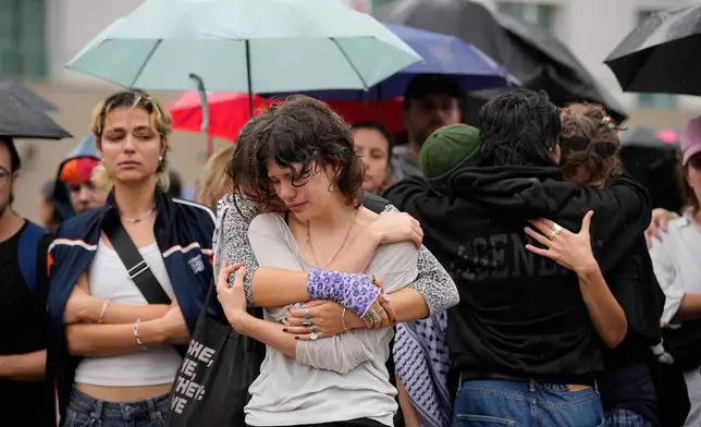 People gather outside the Brandenburg Gate for a demonstration in support of LGBTQ+ after a car rammed into a crowd at the Pride March in Berlin, Sunday, July 26, 2026. (AP Photo/Ebrahim Noroozi)