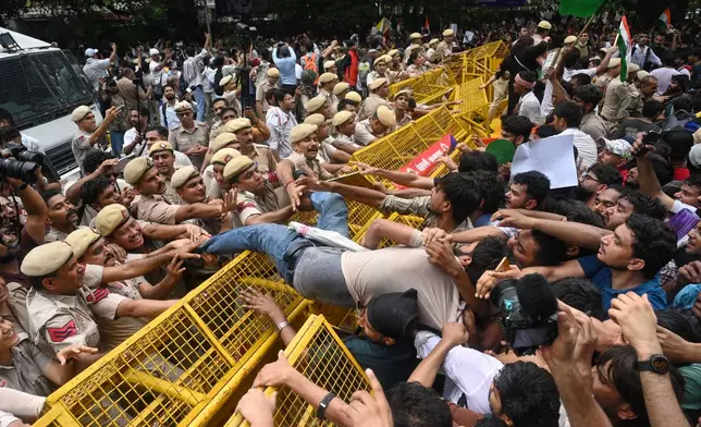 Supporters of the Cockroach Janta Party scuffle with police as they attempt to march toward India's Parliament, demanding the resignation of the education minister, in New Delhi, Monday, July 20, 2026. (AP Photo/Vipin)